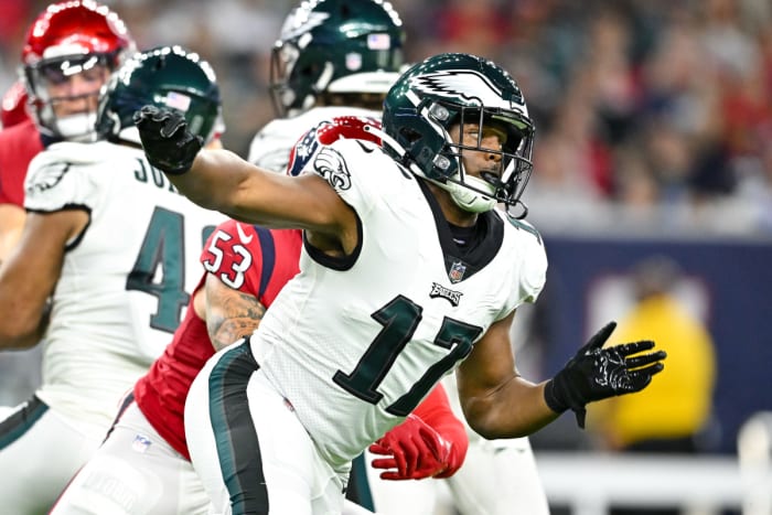 Nakobe Dean runs forward with his arms spread out